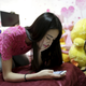 Online hostess Xianggong checks her mobile phone as she sits on her bed after a live broadcast